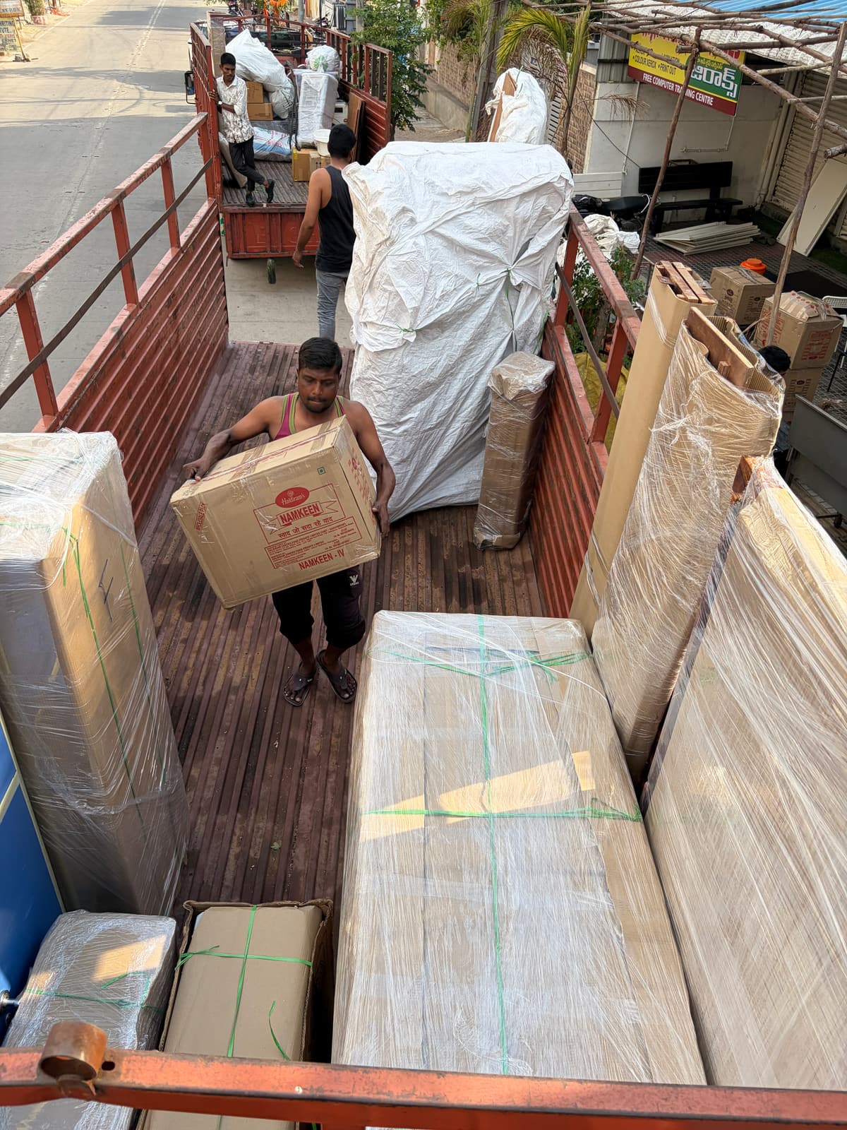 Dwaraka team loading packed household goods into a lorry for a move from Sircilla